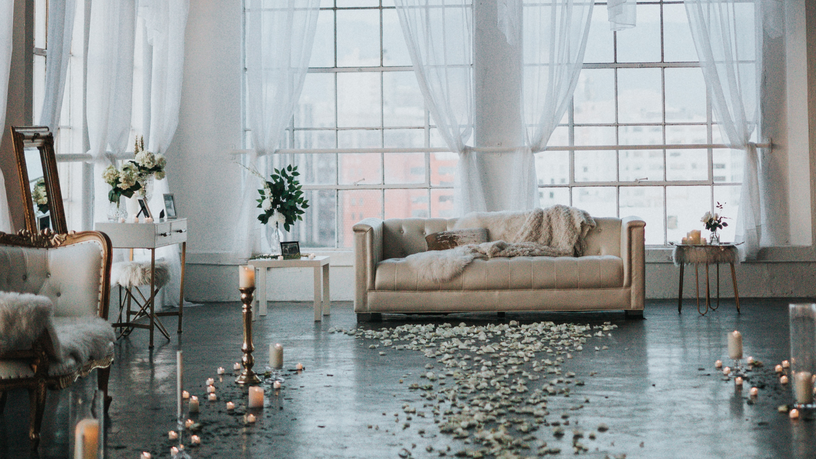 white lounge sofa candles petals arched windows