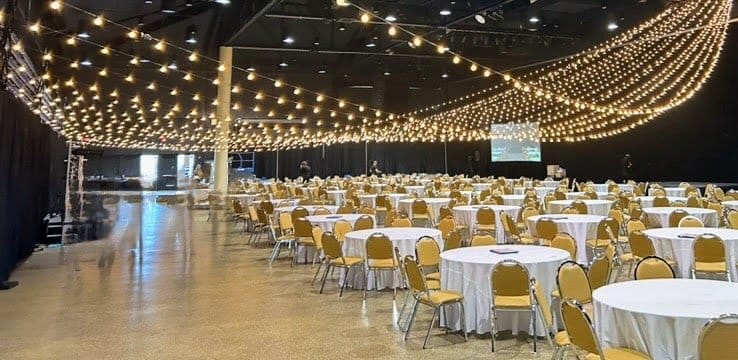 Corporate gala setup with round tables and ceiling string lights by Gabro Event Services