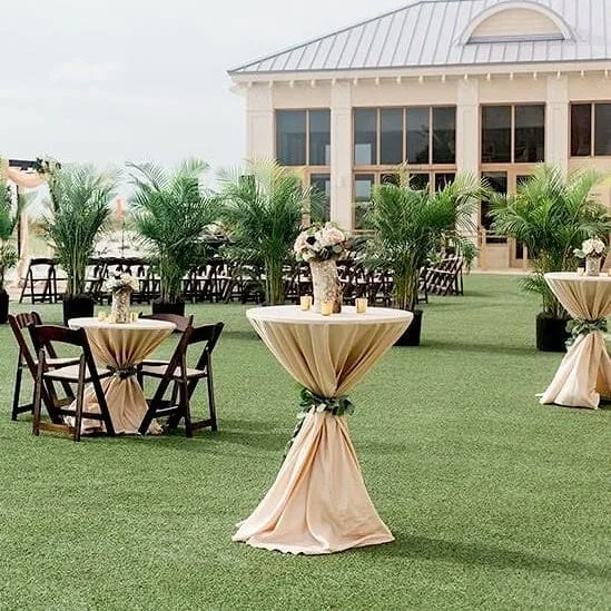 Cocktail tables with yellow linens set up outside building
