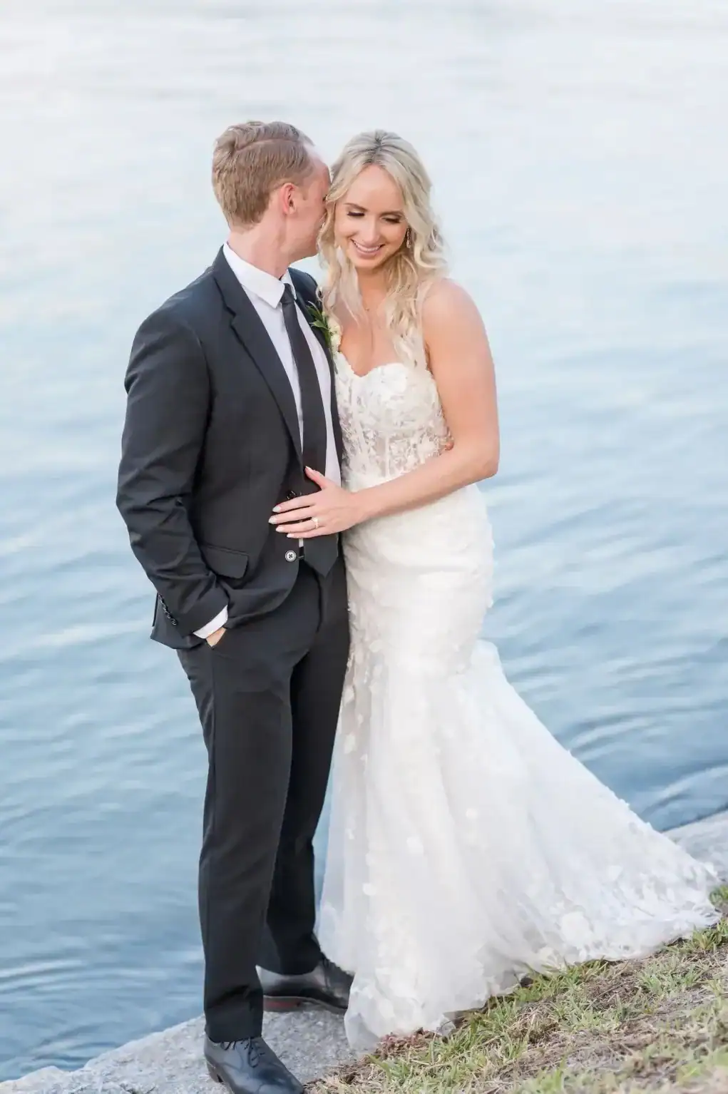 Katie and Alex stand beside the water after their Davis Islands Garden Club wedding ceremony