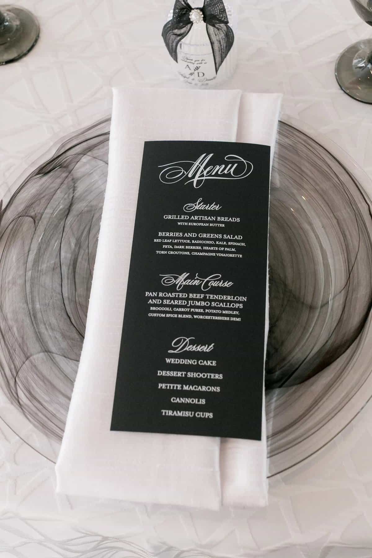 Printed menu card resting on a marbled charger with a white napkin and glassware