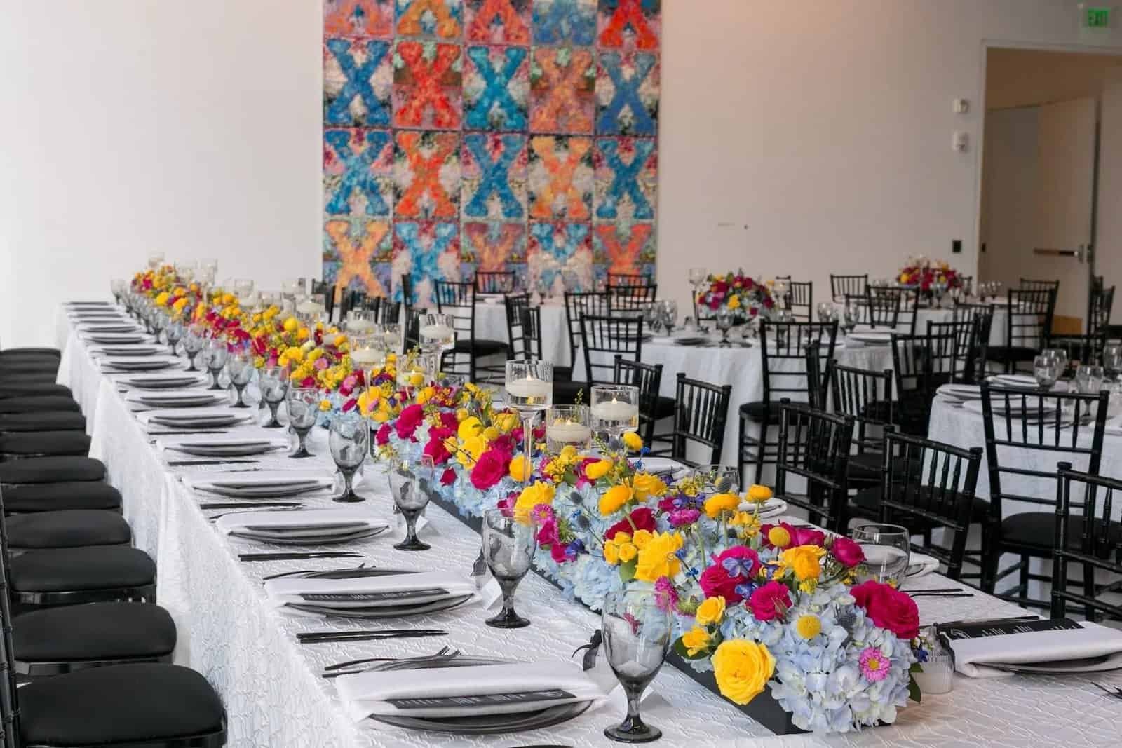 Vibrant feasting tables with modern black chairs and magenta floral accents at The Dali Museum