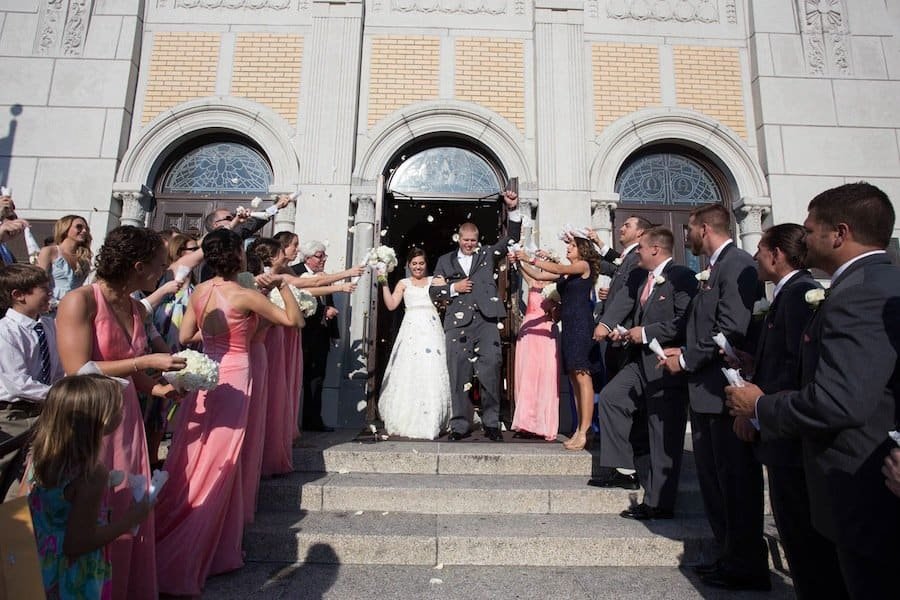 Bride and groom recessional with guests throwing rose petals at St. Nicholas Greek Orthodox Cathedral