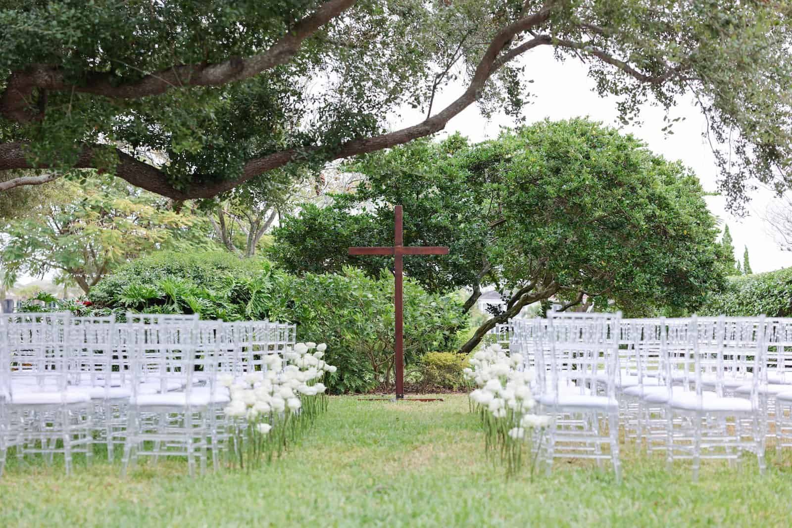 Rows of white Chiavari chairs on the lawn at Davis Island Garden Club under live oaks