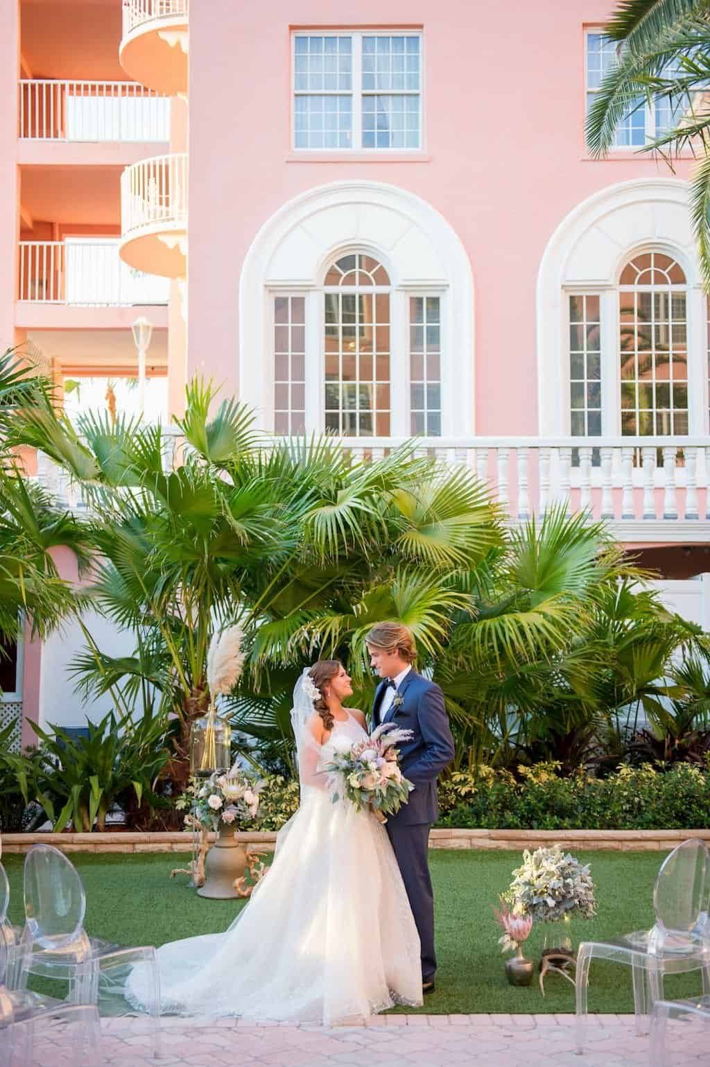 Bride and Groom Exchanging Wedding Vows Under Garden Gazebo Arch with White Florals and Eucalyptus