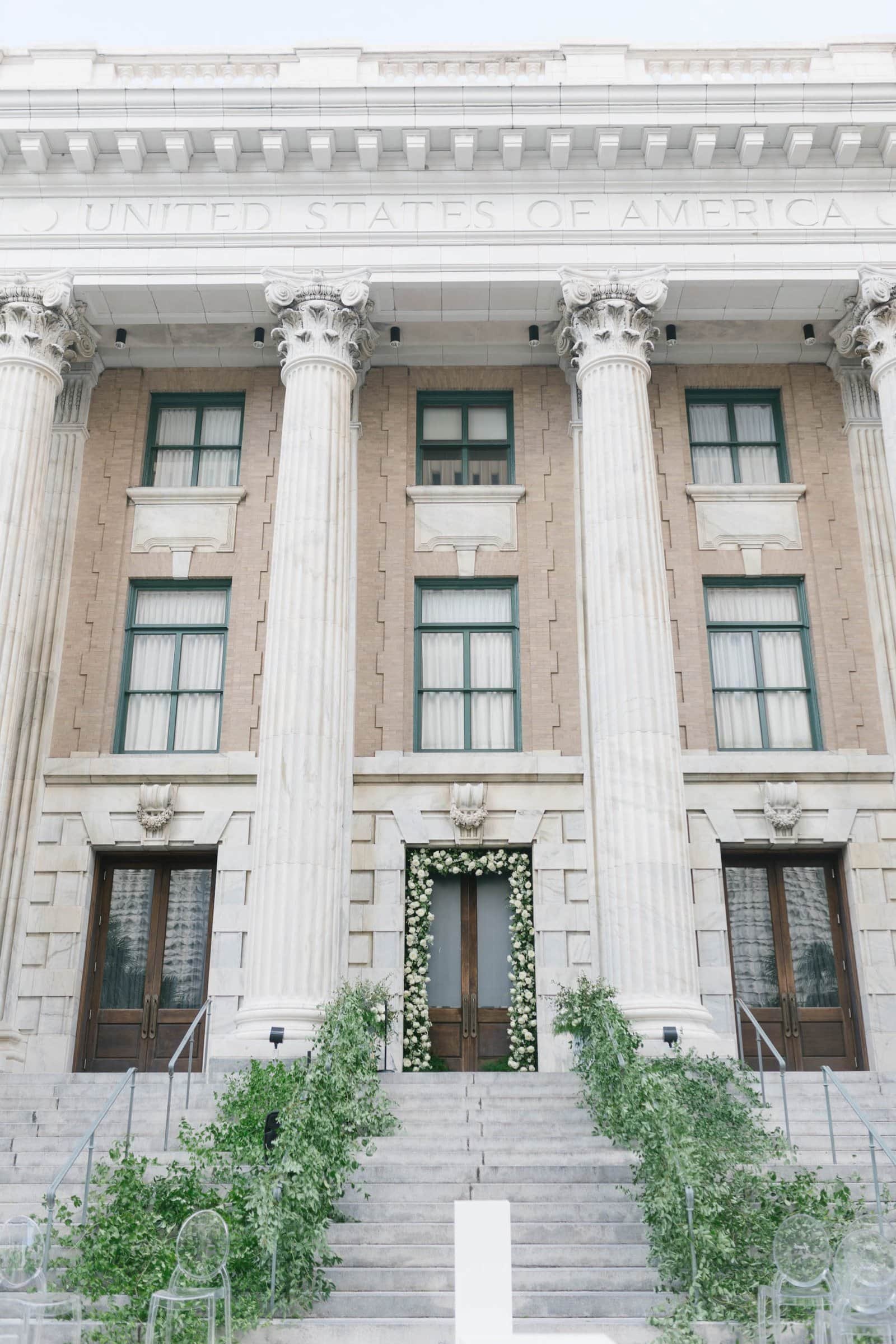 Outdoor wedding ceremony setup with lush floral arch on the historic steps of Le Méridien Tampa