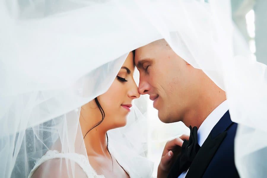 Romantic Bride and Groom Portrait Under Cathedral Length Lace Veil in Downtown Tampa