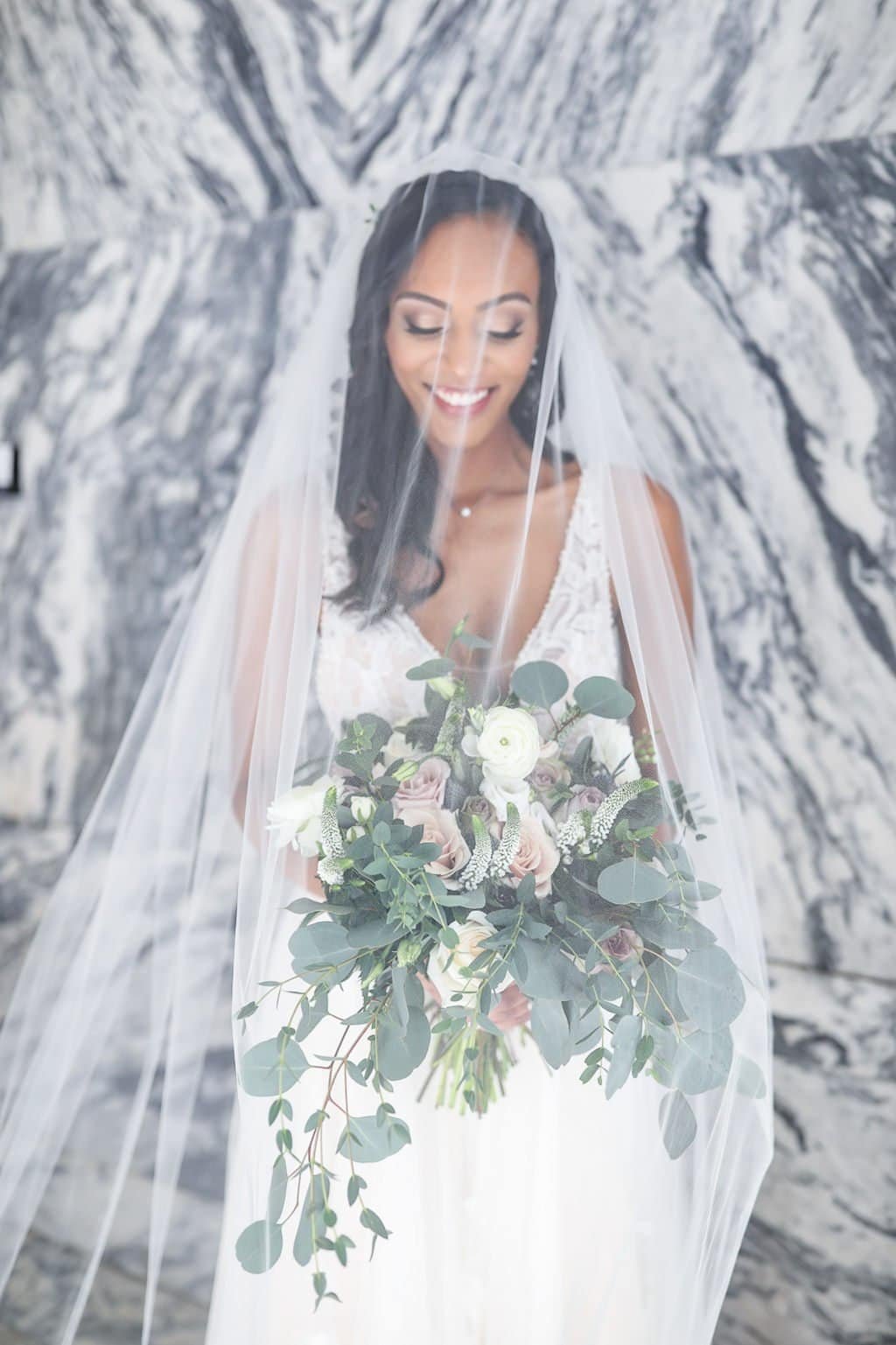 A close-up shot of soft mauve linens and greenery in a brick venue.