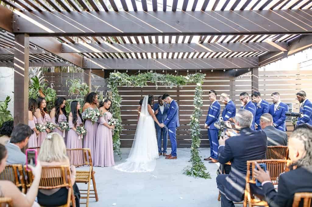 Natural wood chairs and neutral table settings at a bohemian wedding reception.