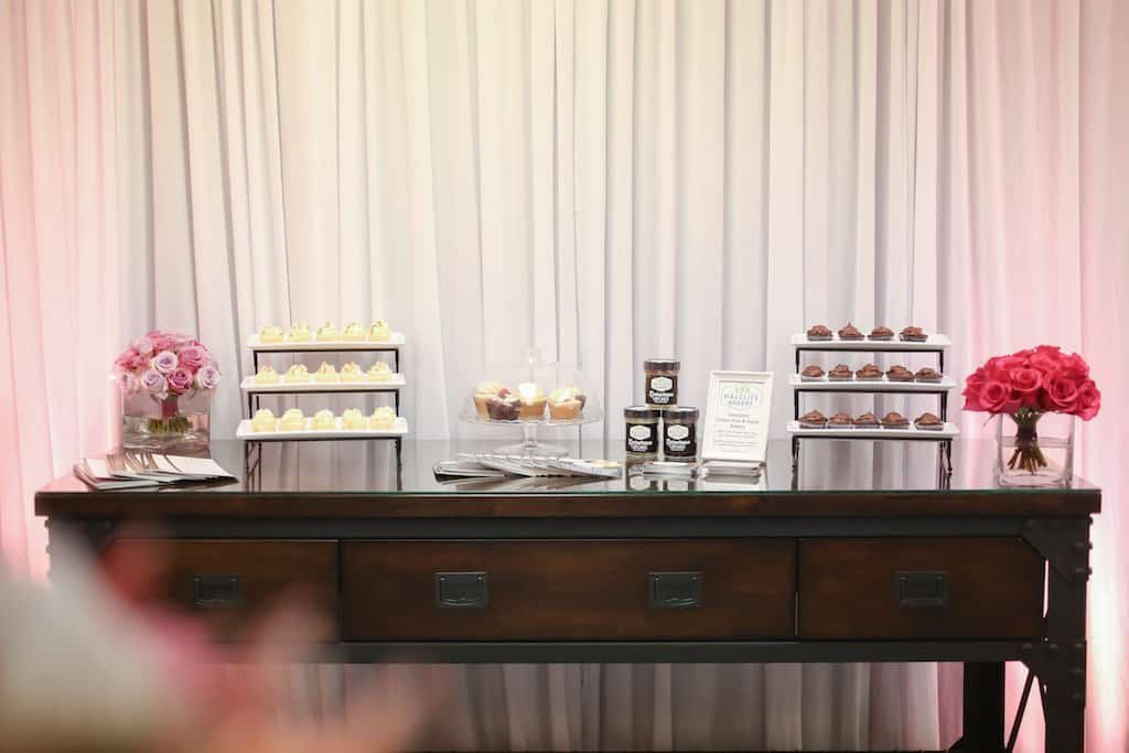 Industrial vintage dessert presentation featuring tiered trays, confectionery favors, and rose accents