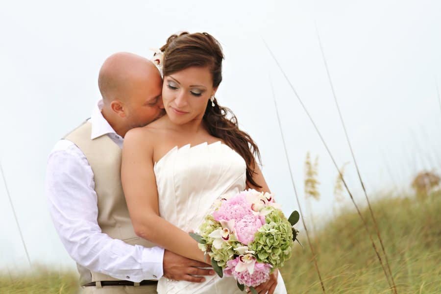 A romantic beachfront ceremony setup at Sand Key Park with pink floral accents.