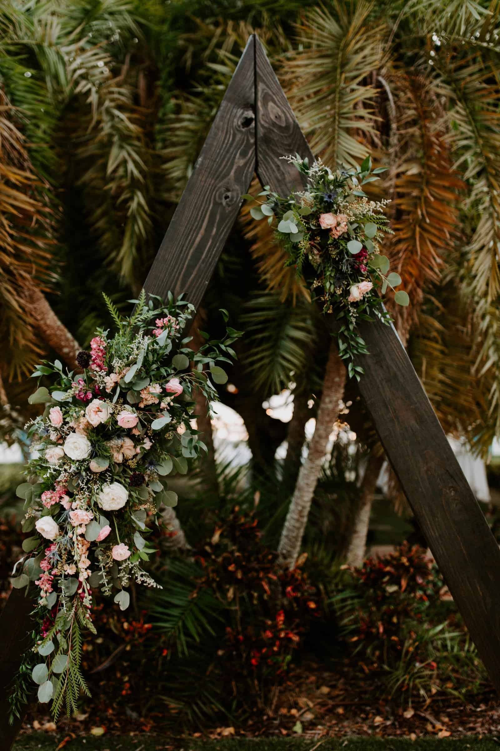 Wedding reception tables featuring unique lottery ticket favors and natural tropical decor elements.