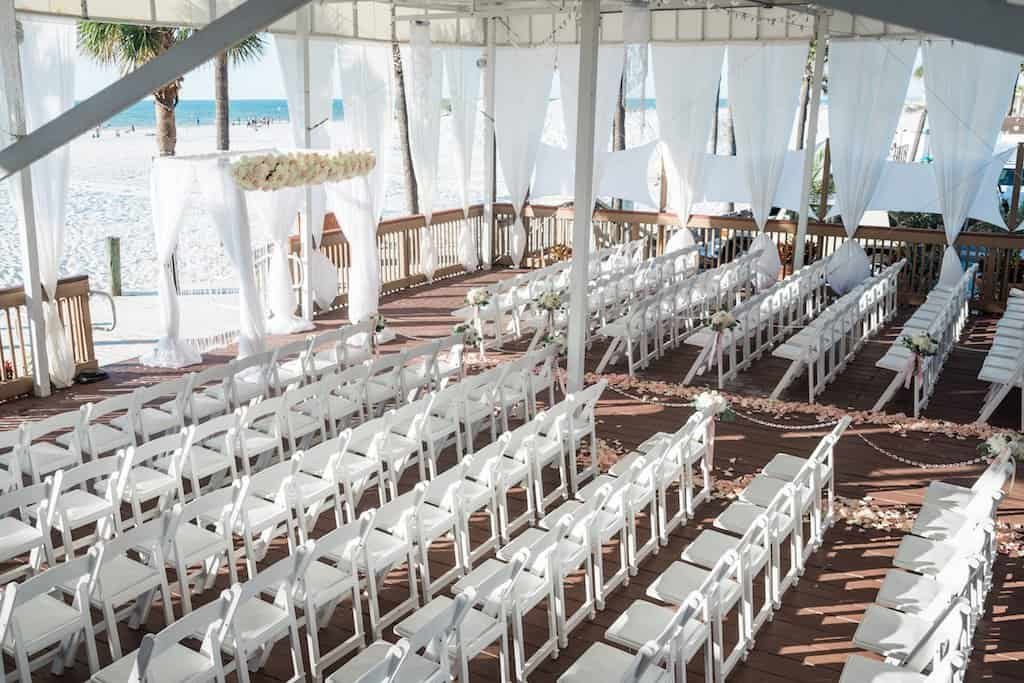 Sandpiper Deck Ceremony Setting with White Chuppah Arch and Chairs by Gabro Event Services