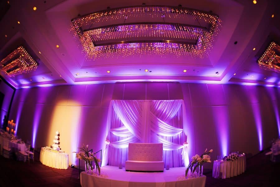 Grand Ballroom Reception Decor with White Drapery and Dramatic Purple Uplighting