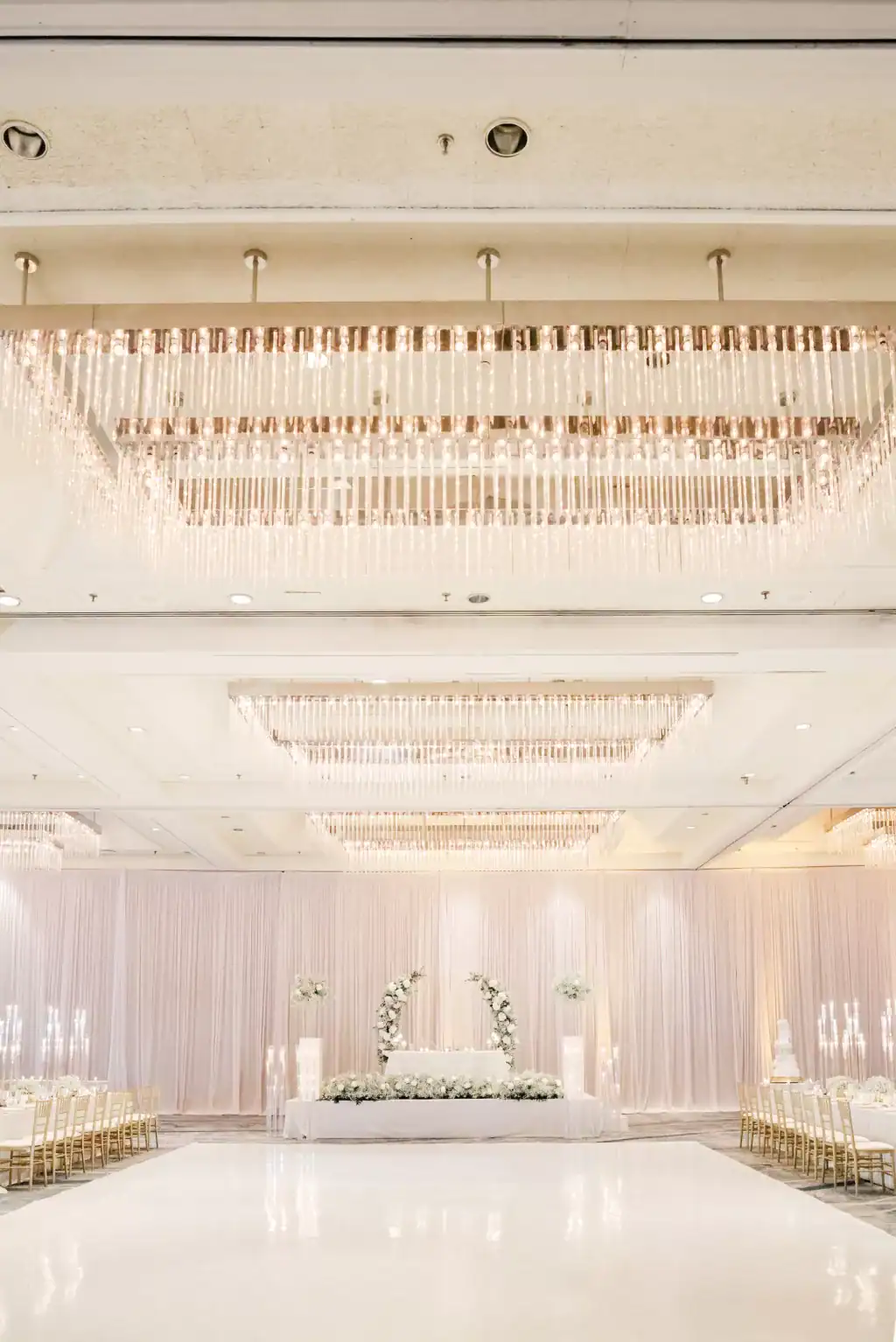 White dance floor under crystal lighting with draped walls behind at the Hilton Tampa Downtown