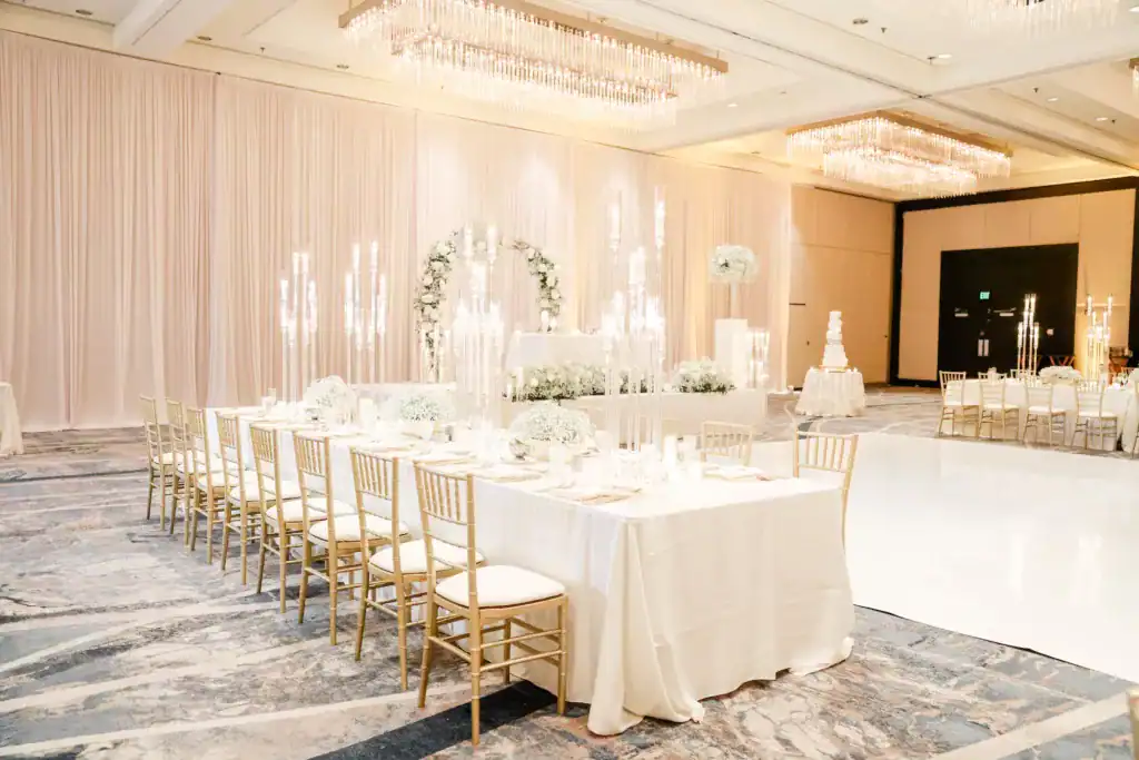Extravagant reception feasting tables with tall acrylic candelabras and gold Chiavari chairs
