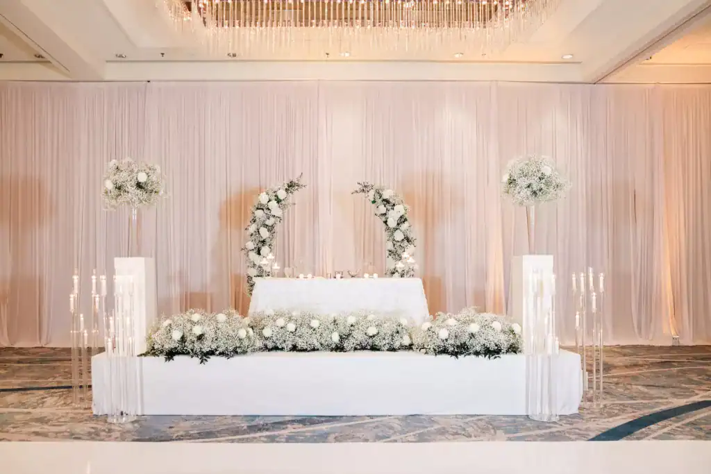 Extravagant modern sweetheart table framed by lush baby's breath and floral floor arrangements