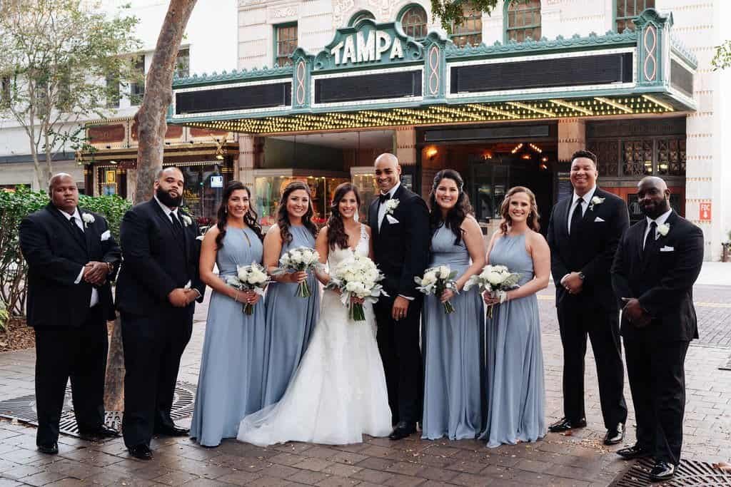 Full Wedding Party with Bridesmaids in Dusty Blue Dresses Outside Historic Tampa Theatre in Downtown Tampa