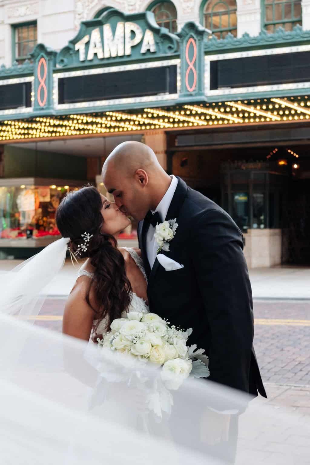 Bride and Groom Romantic Veil Kiss Outside Historic Tampa Theatre by Grind and Press Photography