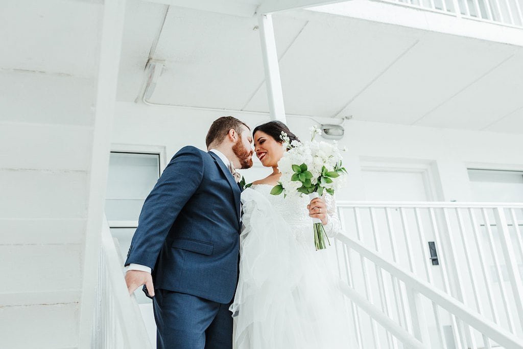 The happy couple sharing a private first look moment in a sunlit garden.