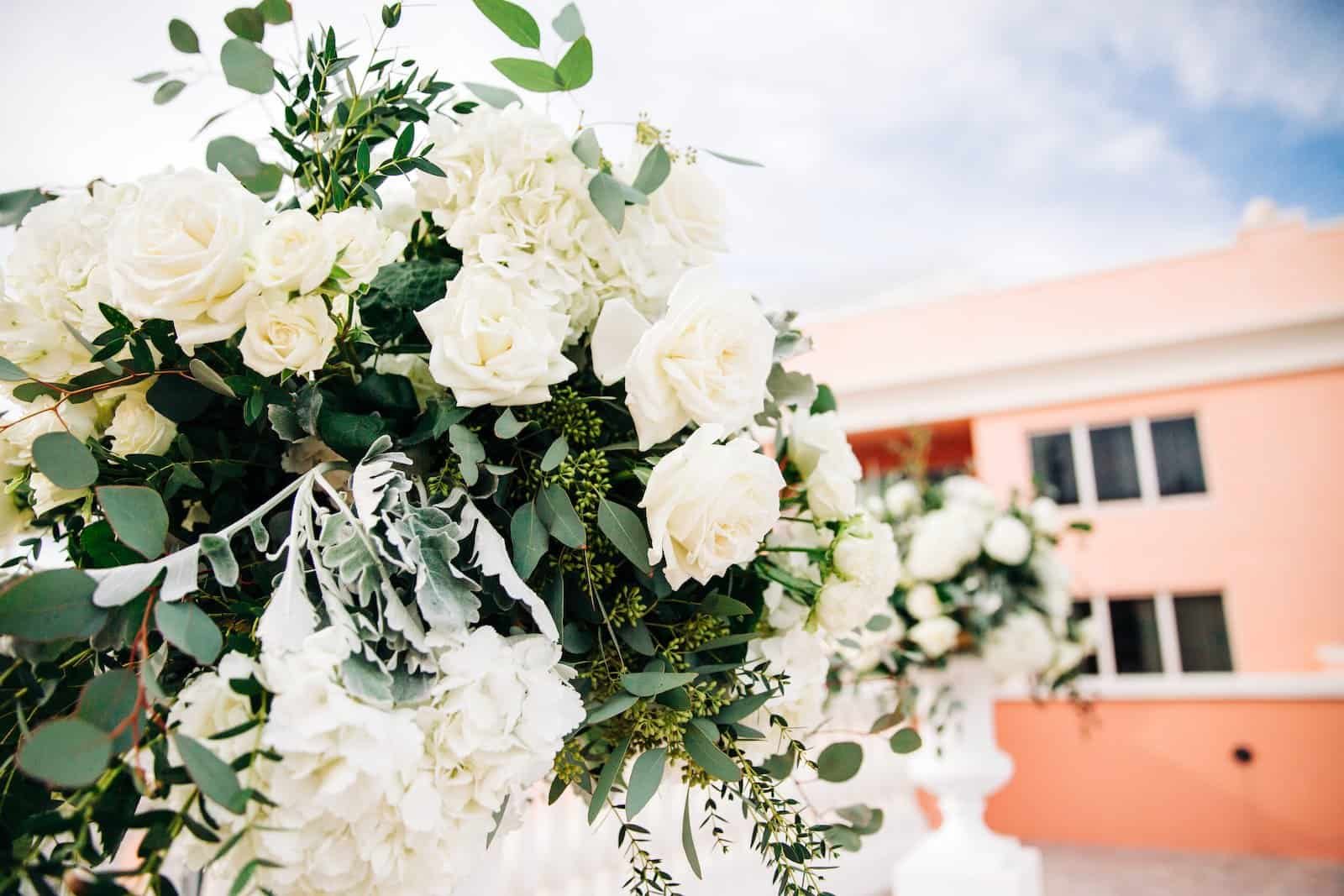 A breathtaking rooftop wedding ceremony featuring white floral arrangements overlooking the blue ocean.