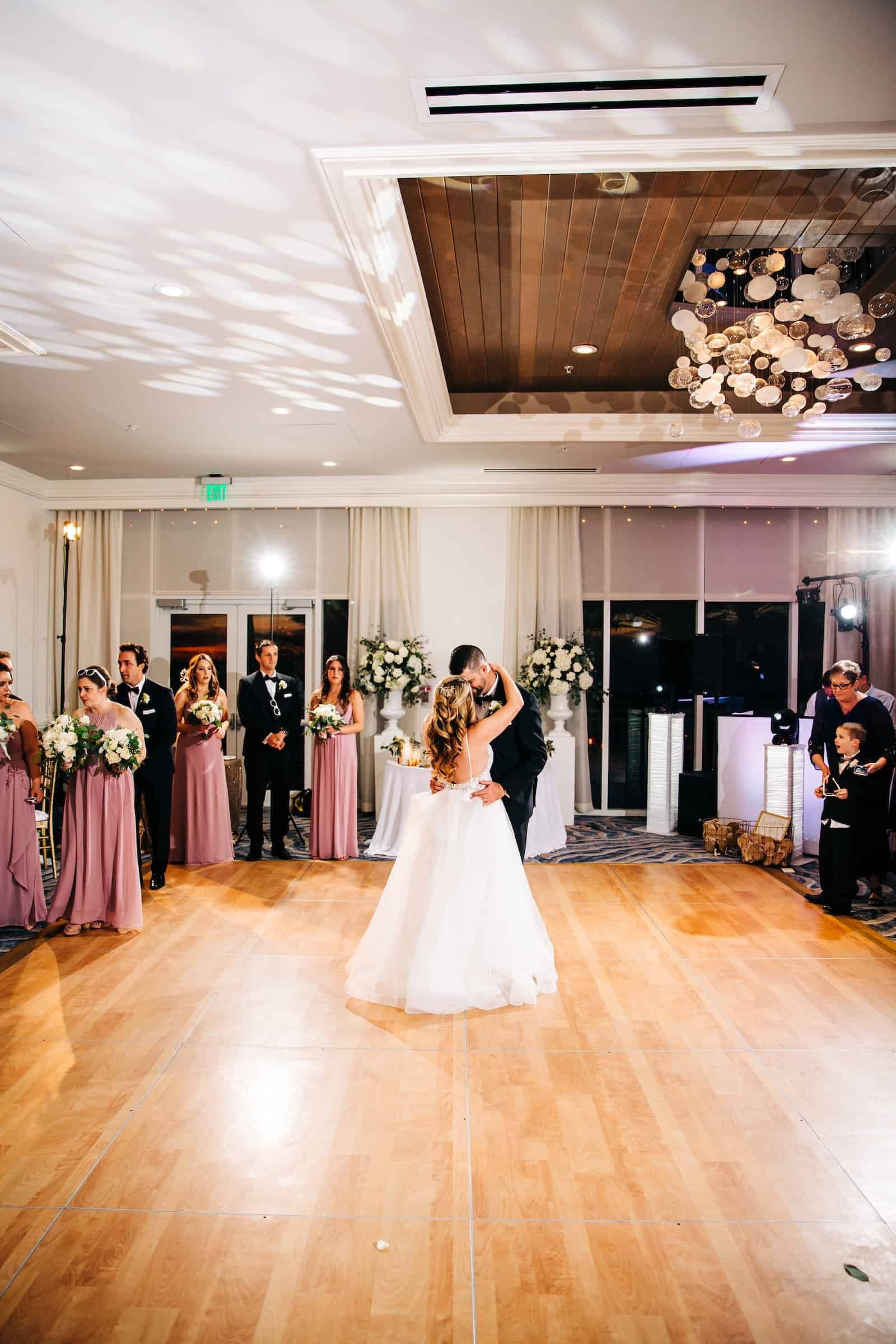 A lively wedding reception dance floor with guests celebrating and a custom floor.