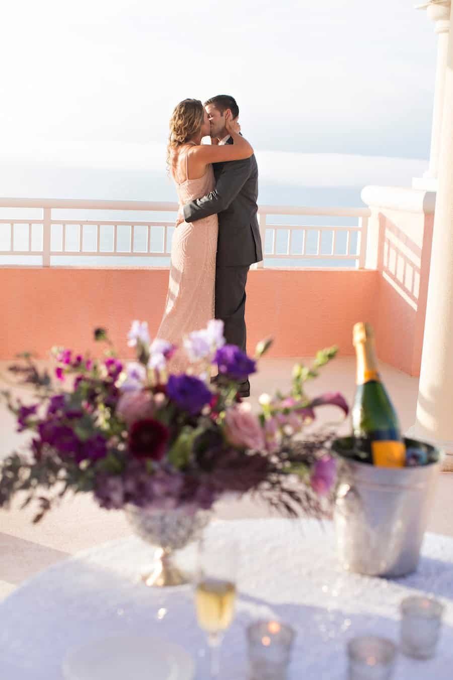 Groom-to-be on bended knee proposing to surprised bride on the open-air rooftop sky terrace at Hyatt Regency Clearwater Beach
