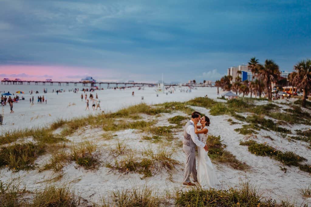 Ballroom wedding reception at Hyatt Regency Clearwater Beach featuring navy blue table linens, gold chiavari chairs, and sheer white fabric draping