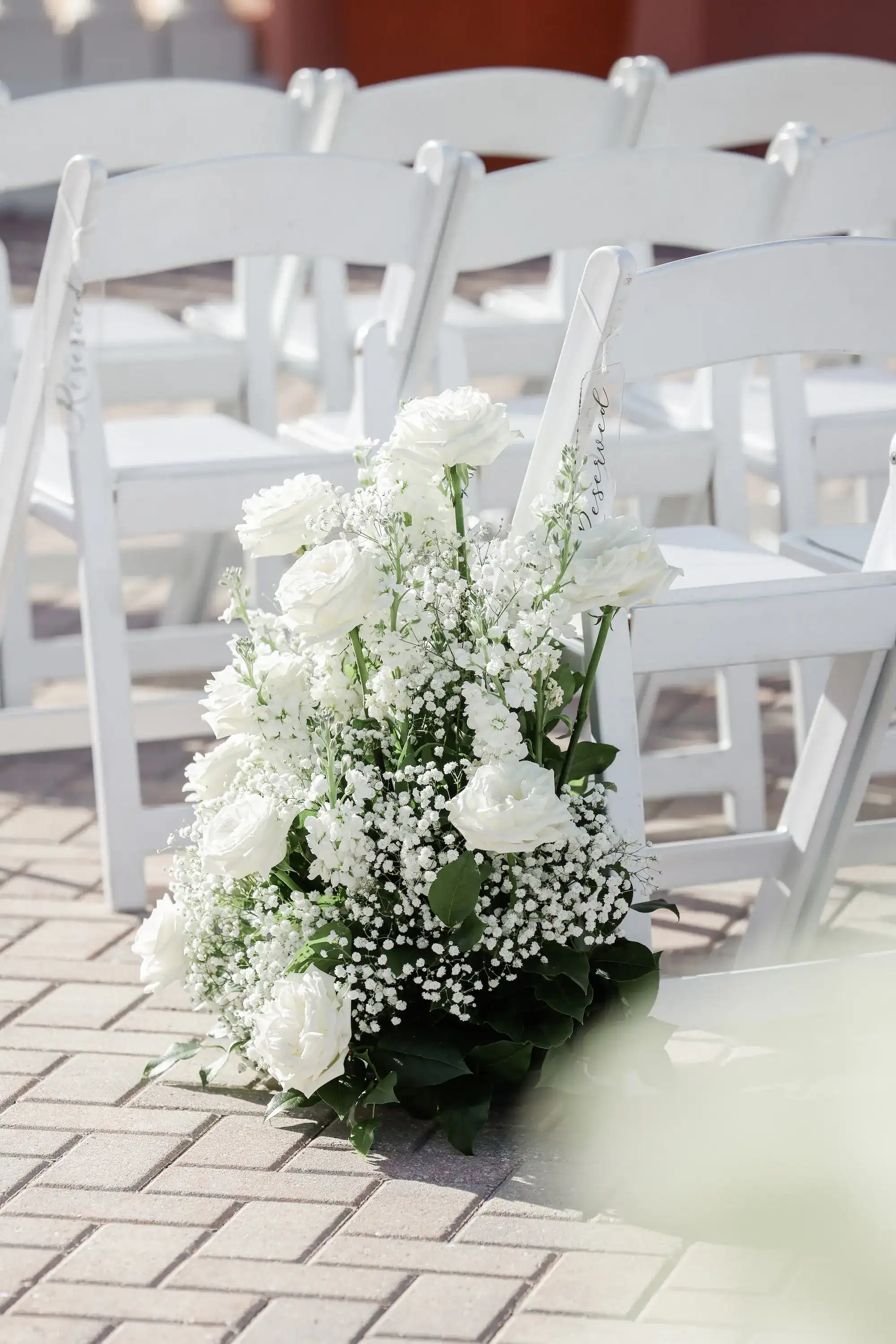 Clearwater Beach rooftop ceremony aisle featuring white ceremony chairs and floral pedestals