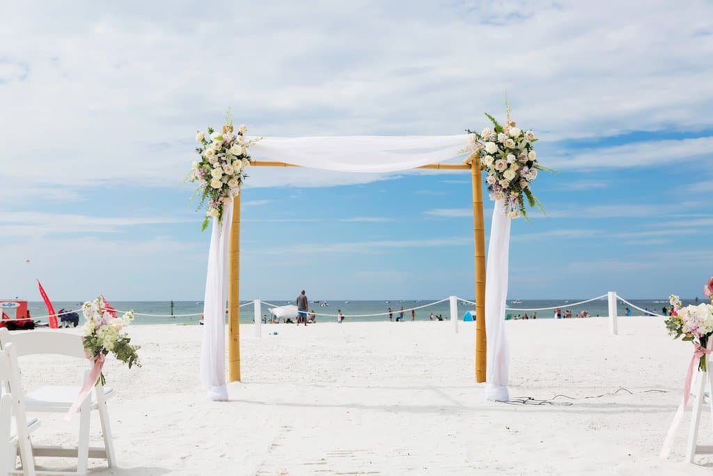 Outdoor rooftop wedding ceremony at Hyatt Regency Clearwater Beach with floral arch and sweeping Gulf views