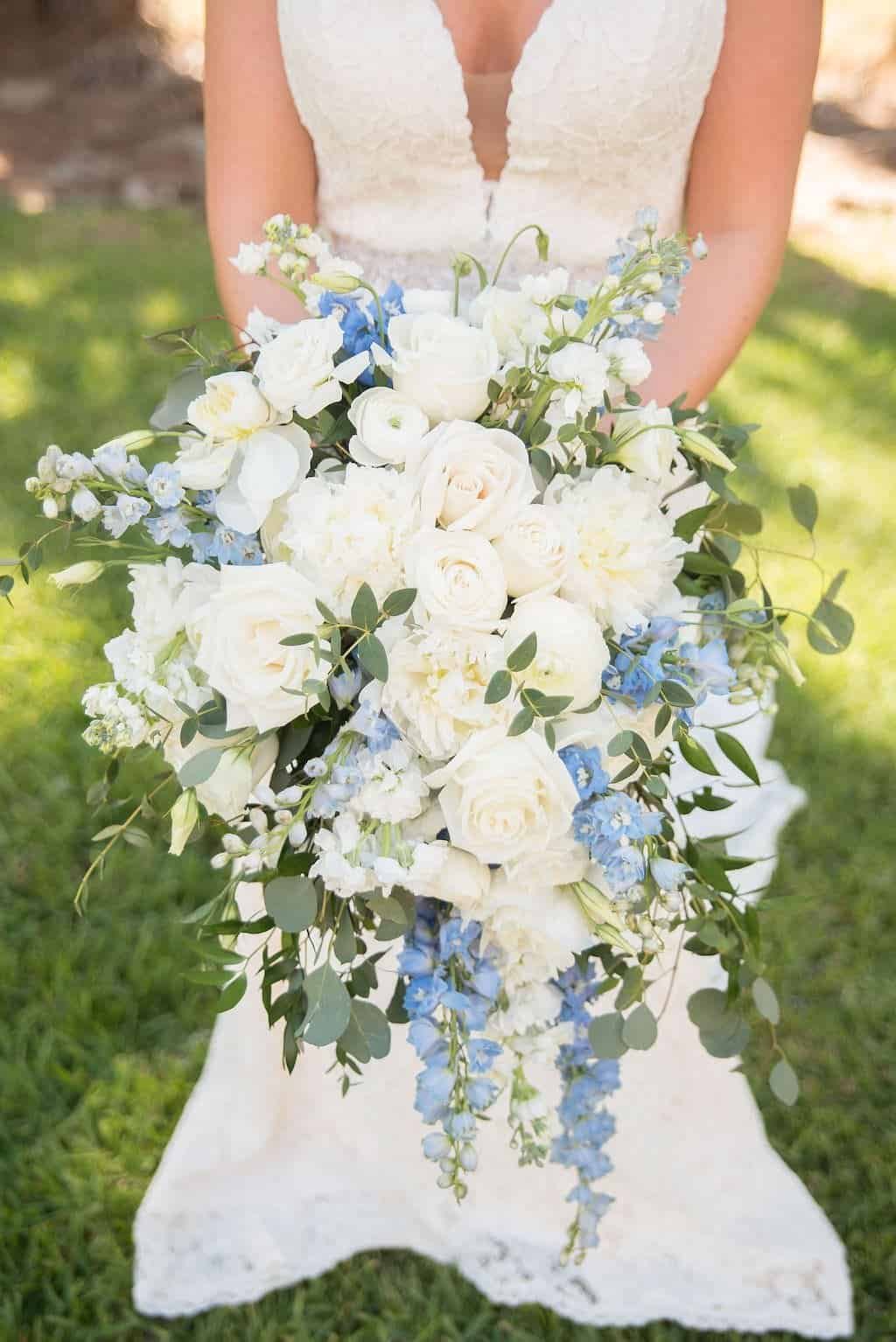 A romantic outdoor ceremony setup beneath large oak trees with Spanish moss hanging.