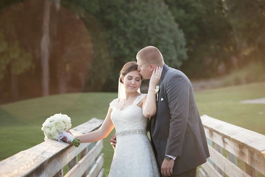 Newlywed bride and groom posing at golden hour along the rolling tree-lined fairways of Innisbrook Resort