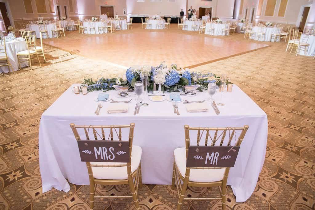 Wedding Reception Sweetheart Table with Gold Chiavari Chairs and Stage Backdrop Fabric Draping by Gabro Event Services