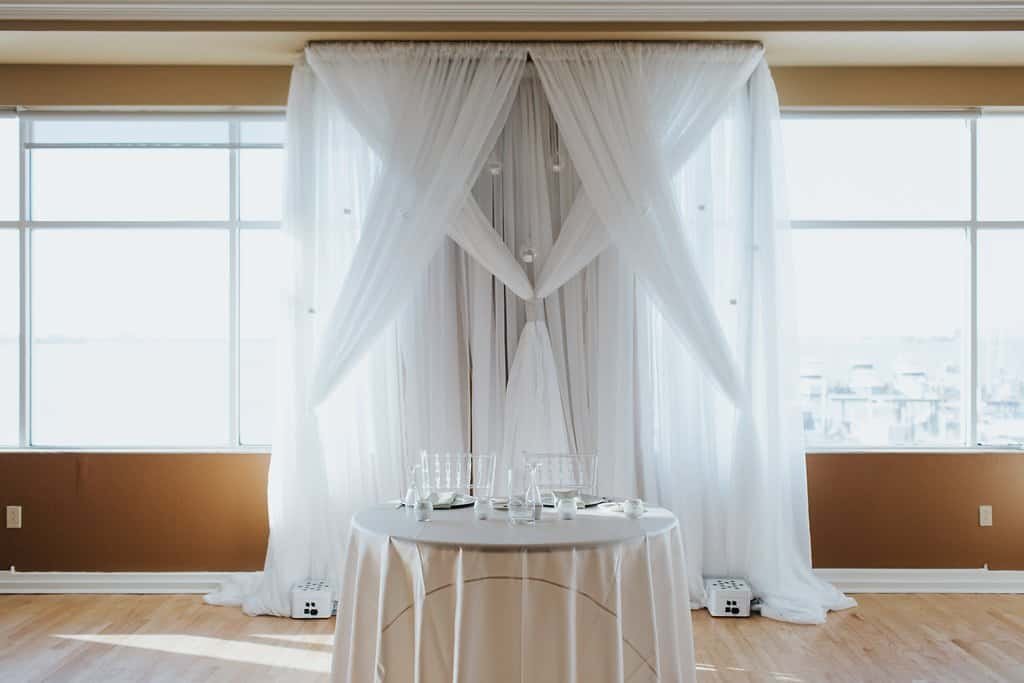 Intimate sweetheart table adorned with lush white and blush florals, textured linens, and elegant chiavari chairs