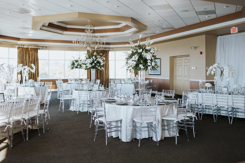 Isla Del Sol Yacht and Country Club ballroom reception featuring clear chiavari chairs, round guest tables, and waterfront views