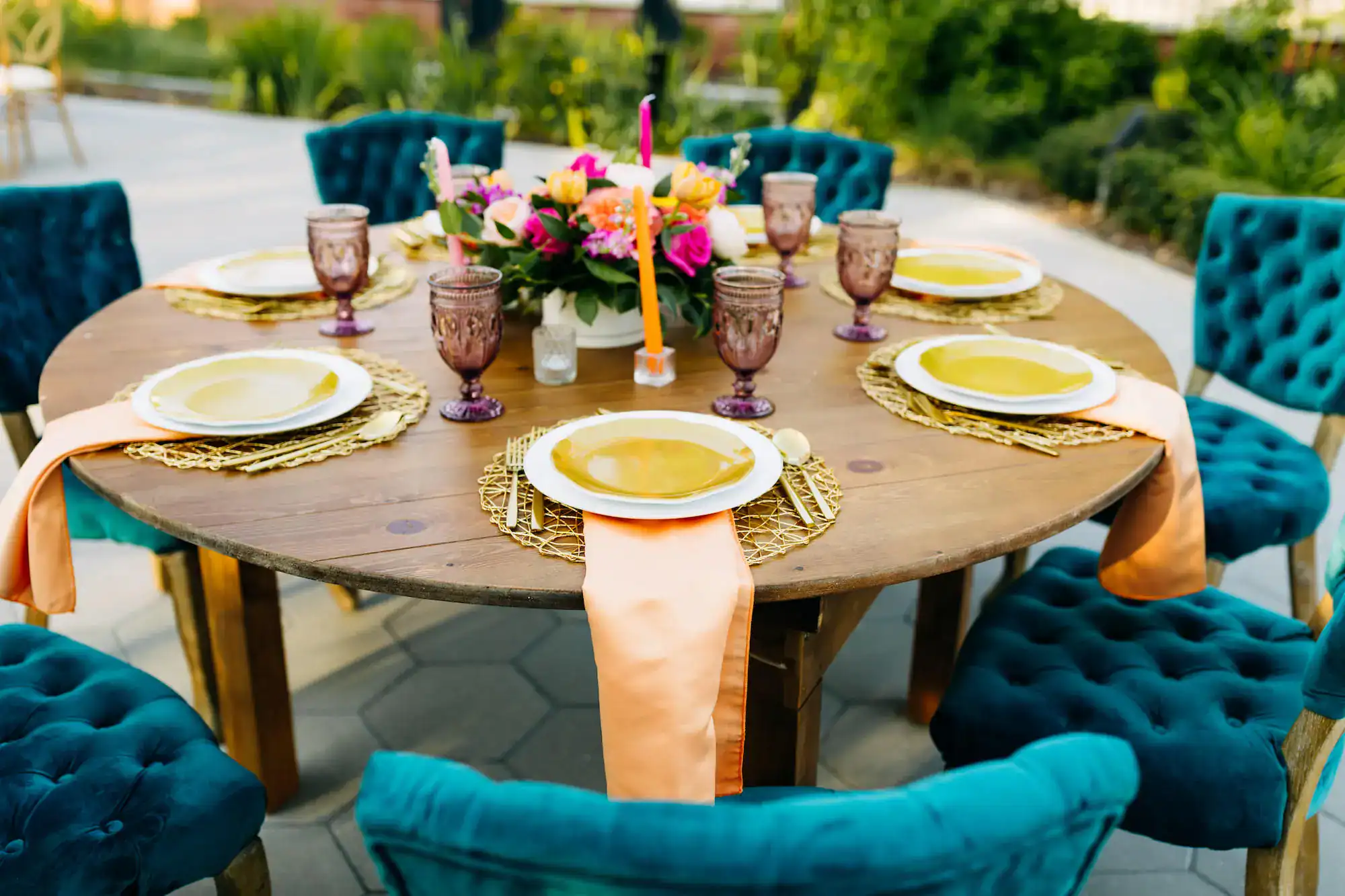 Dining tablescape with royal blue velvet chairs, colorful taper candles, and gold flatware from Gabro Event Services
