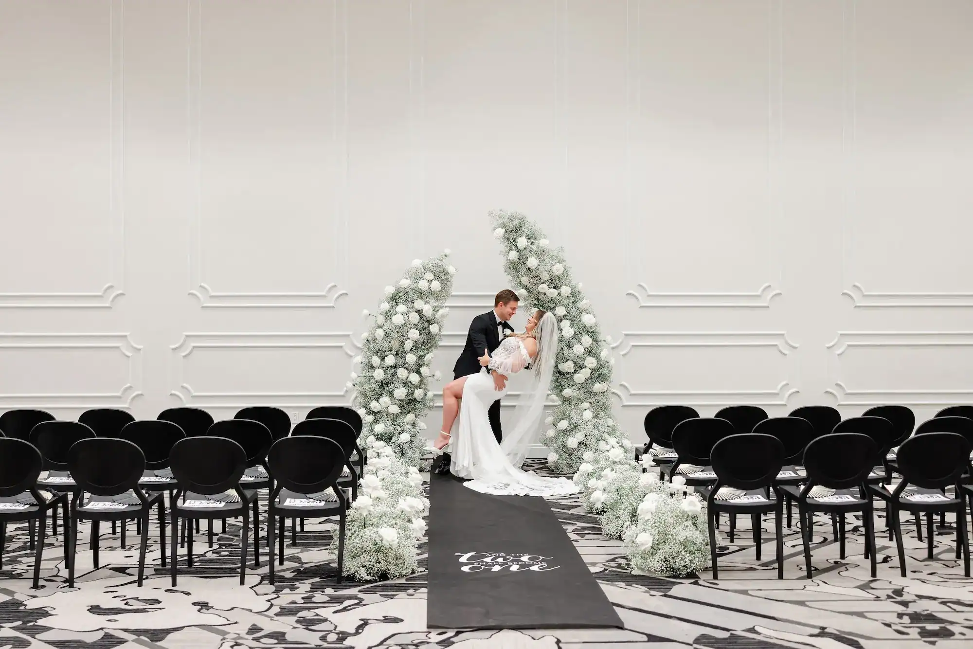 Guests dancing under a canopy of greenery and sparkling disco balls in a ballroom.