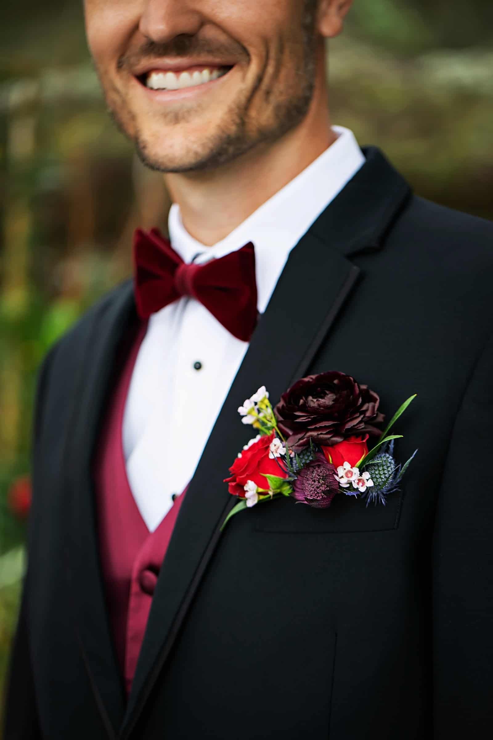 A close-up of burgundy velvet linens paired with gold accents and blush florals.