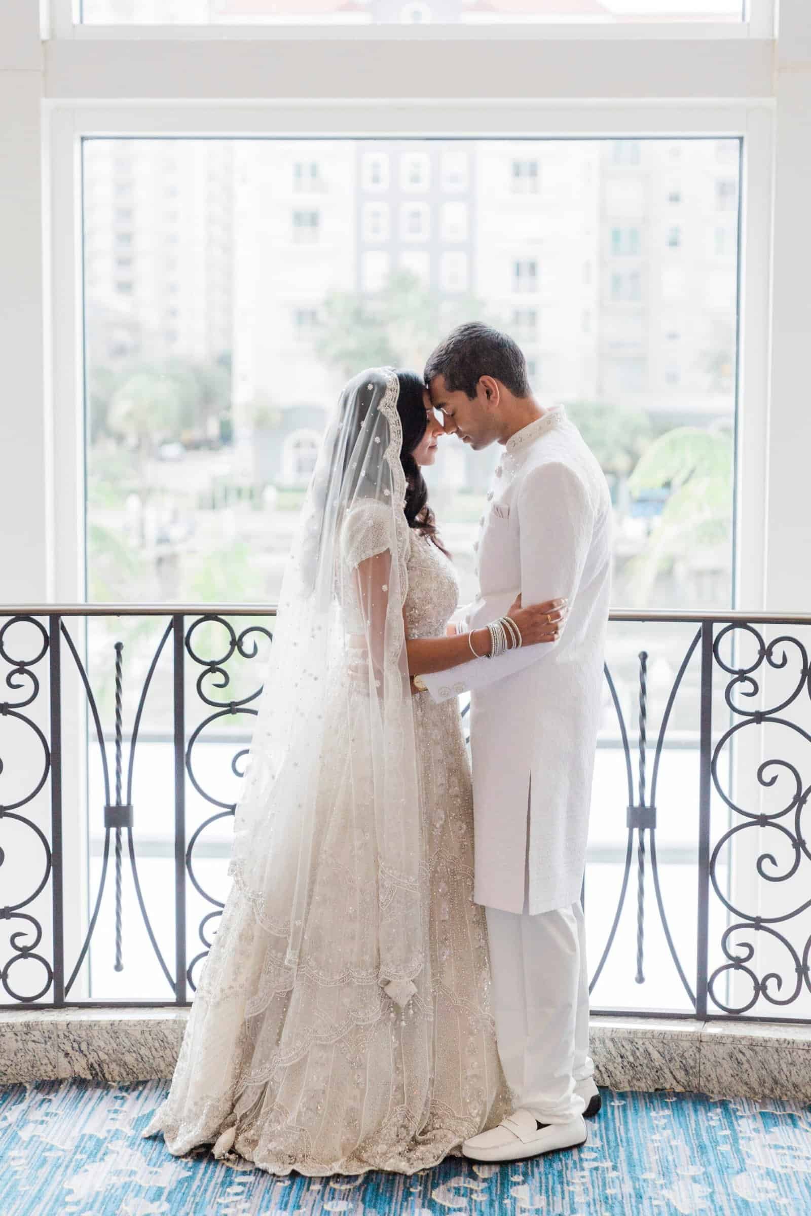 Bride and groom traditional Indian wedding portrait in ivory beaded lehenga and sherwani