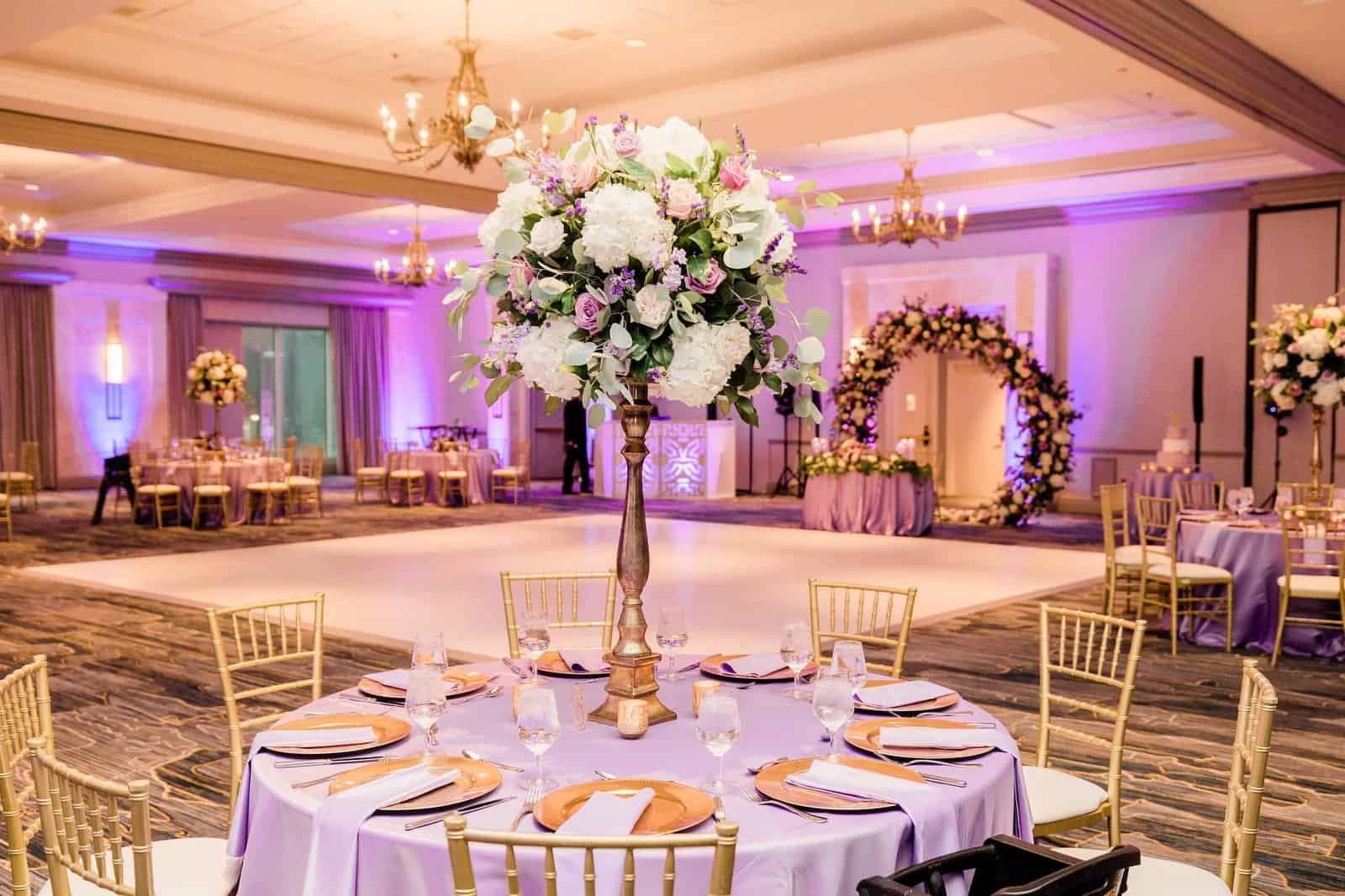 Reception banquet tables styled with floor-length lavender satin linens from Gabro Event Services