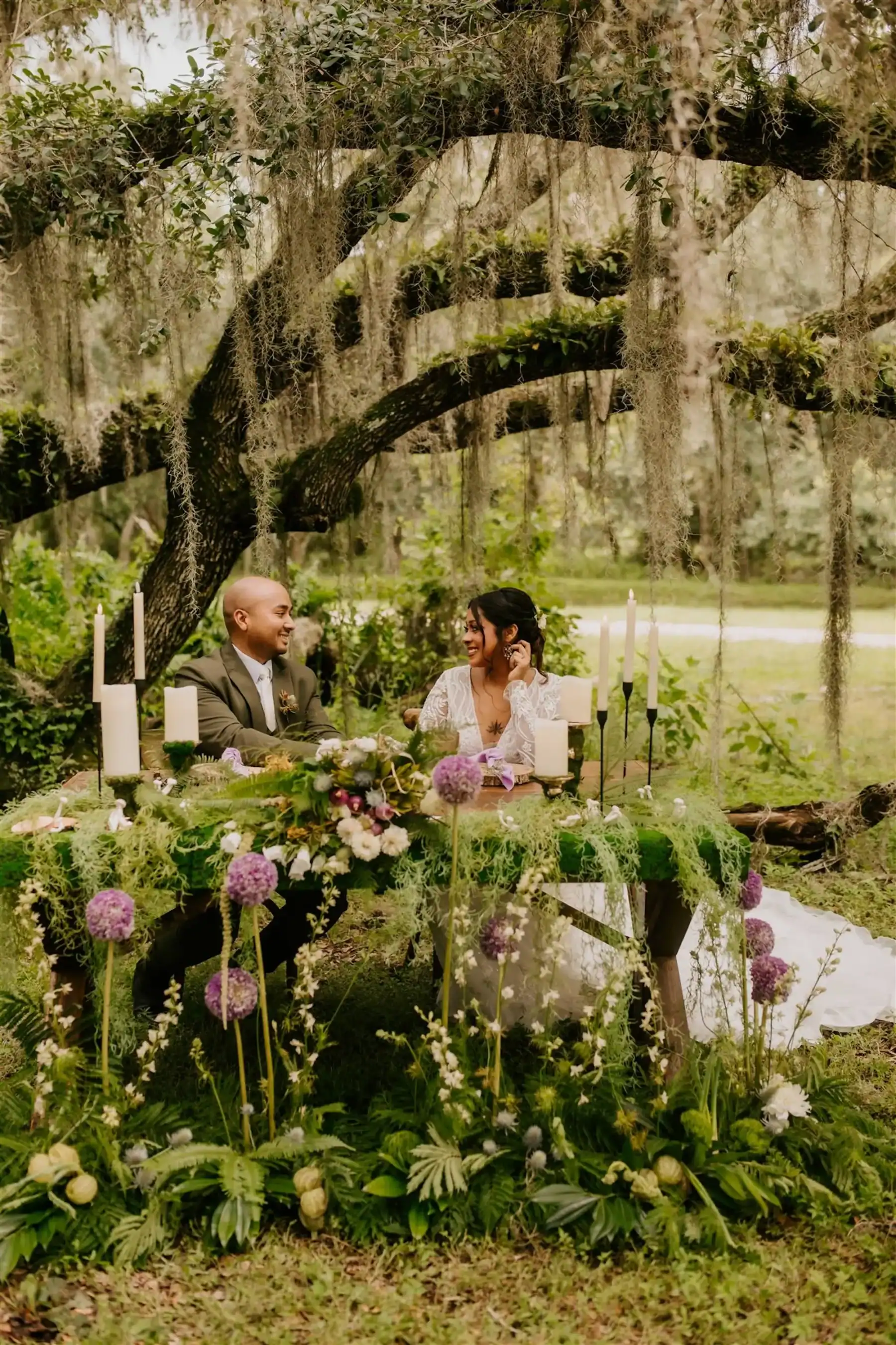 Whimsical woodland forest wedding table setup beneath moss-draped grand oaks at Mill Pond Estate
