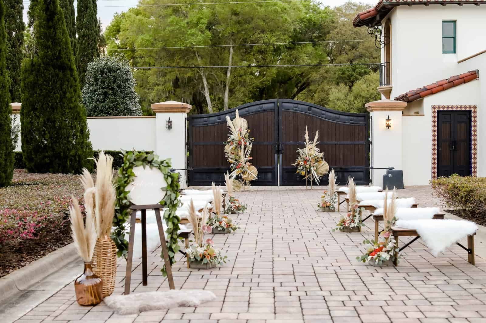 Long wood farm tables set on the brick courtyard between cypress trees at Mision Lago Estate