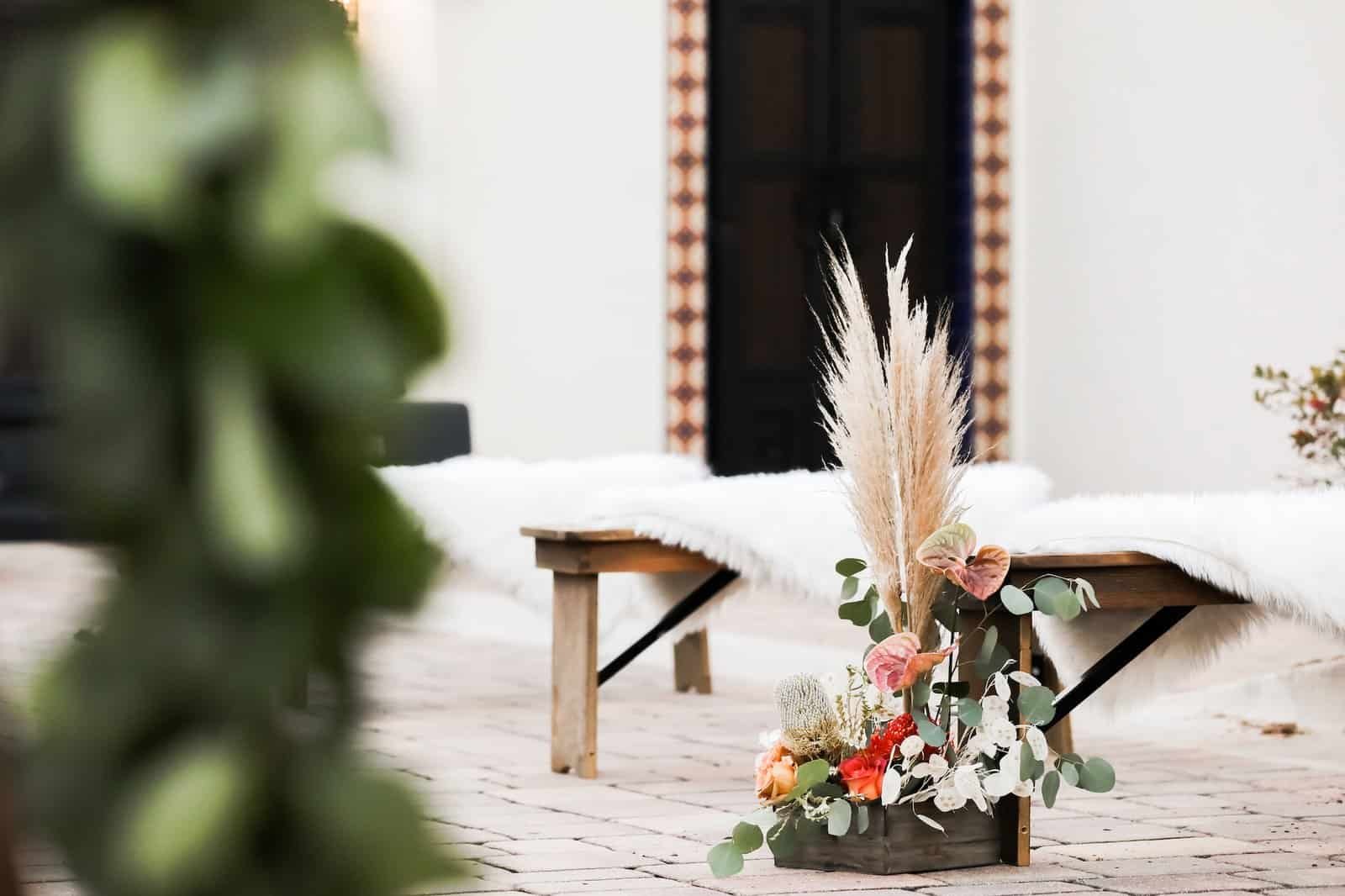 Rustic wooden ceremony benches with plush ivory fur throws from Gabro Event Services