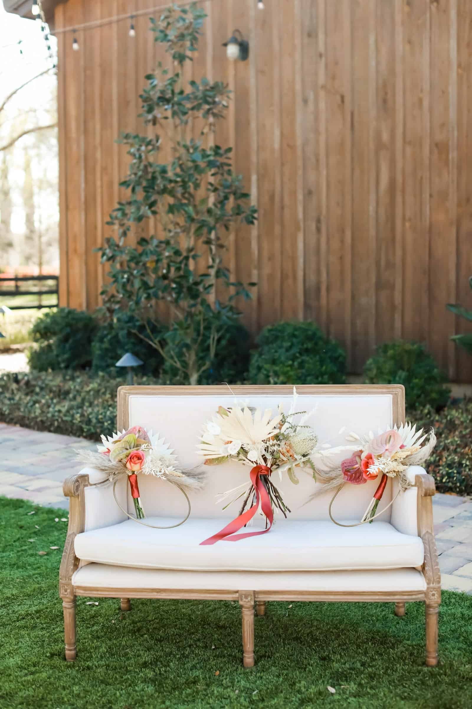 Vintage velvet loveseat lounge with boho bridesmaids in terracotta and rust dresses