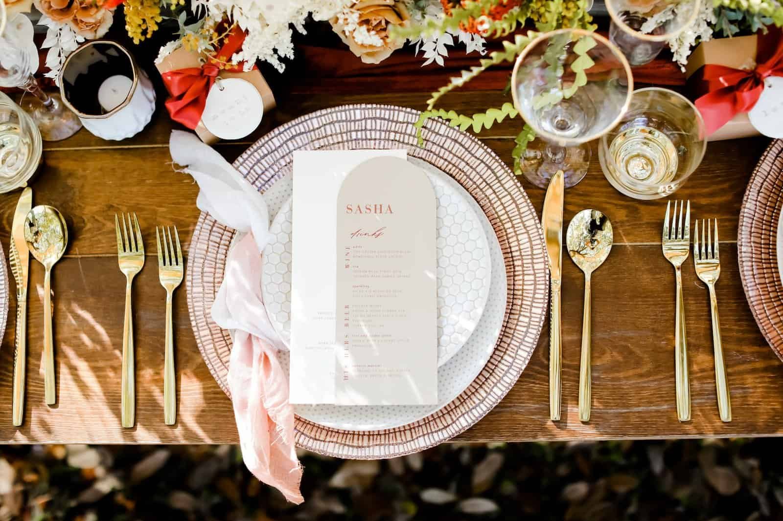 Polished gold flatware and textured clay plate setting from Gabro Event Services