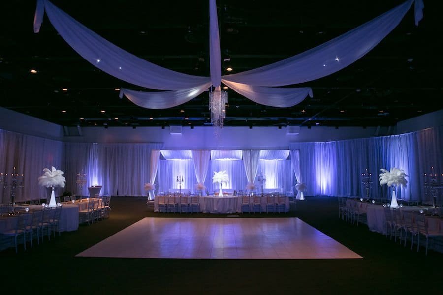 Grand wedding reception ballroom at A La Carte Pavilion featuring Gabro Event Services ceiling fabric treatments and chandeliers