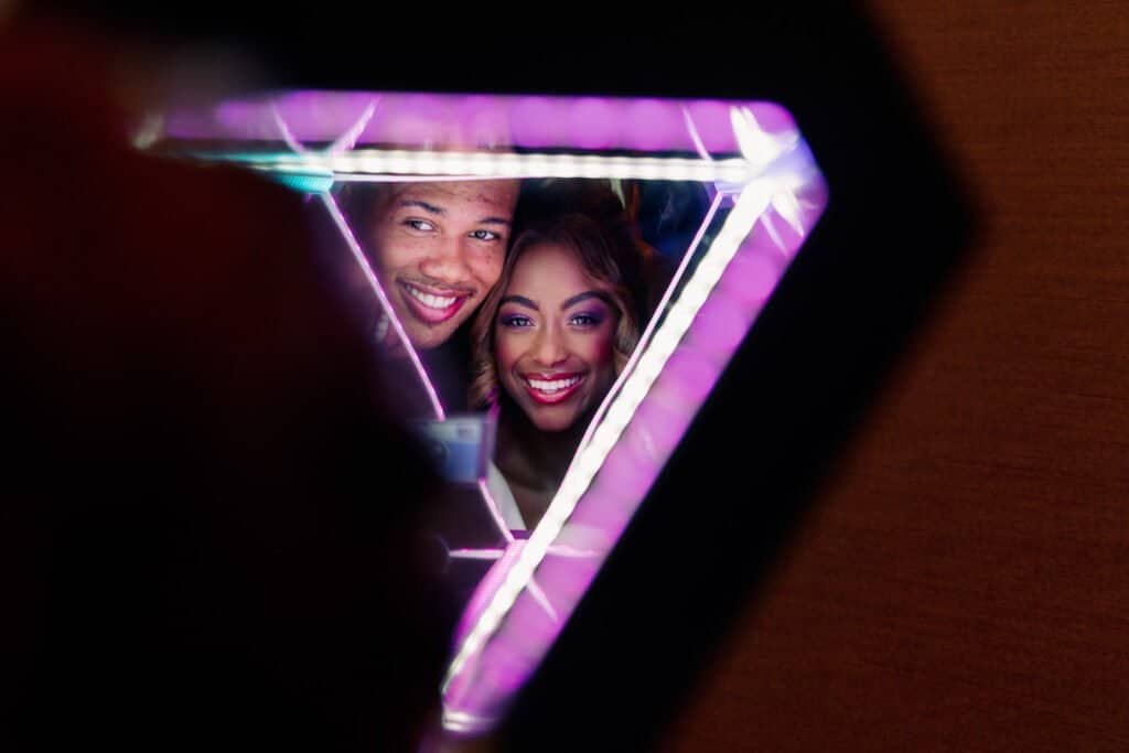 Contemporary Bride and Groom Portrait Framed by a Custom Purple Triangular Neon Light Installation