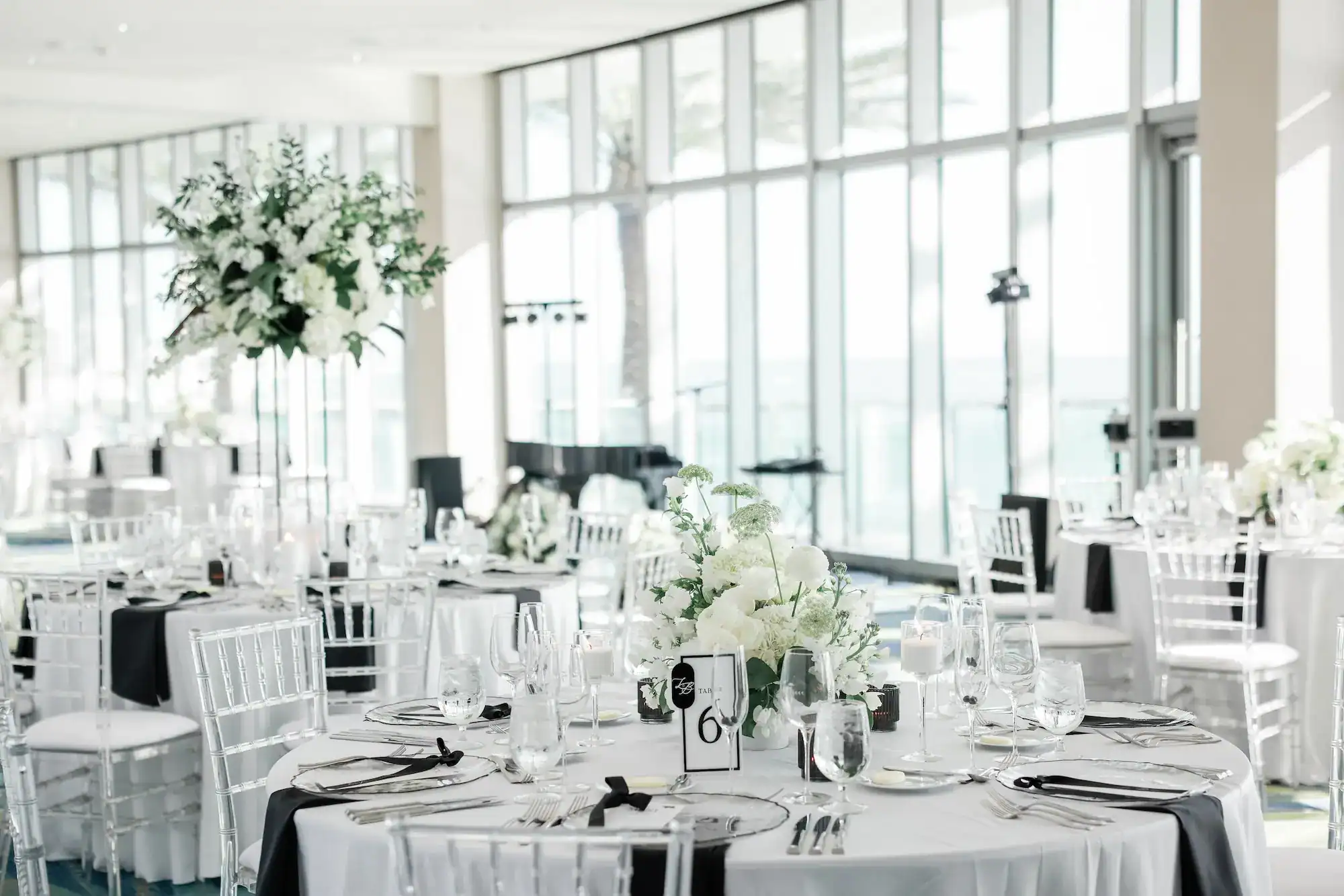 Waterfront Gulf-view wedding ceremony setting with sleek black chairs at Opal Sands