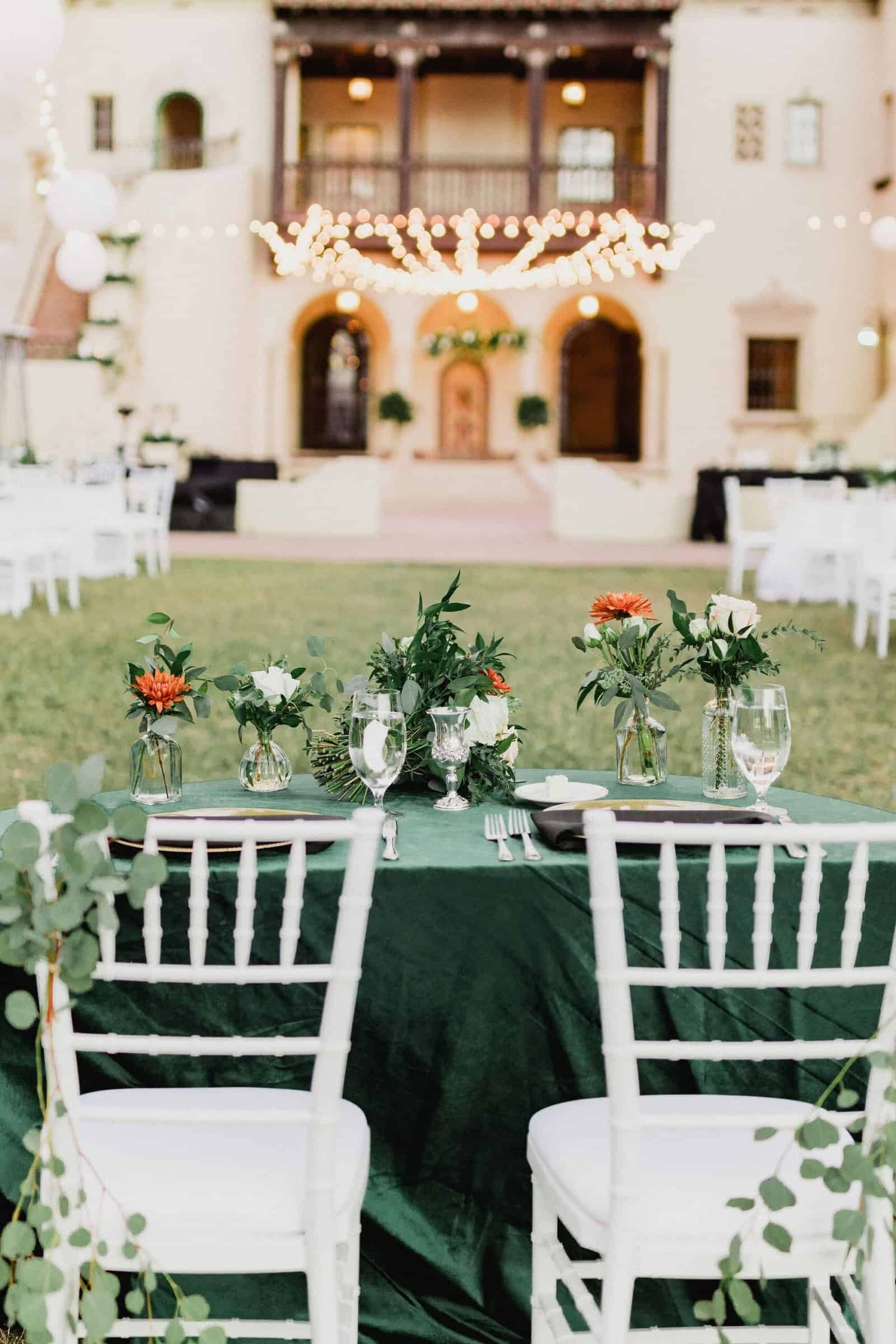 Dining tables set on the terrace at the Powel Crosley Estate beneath globe string lights