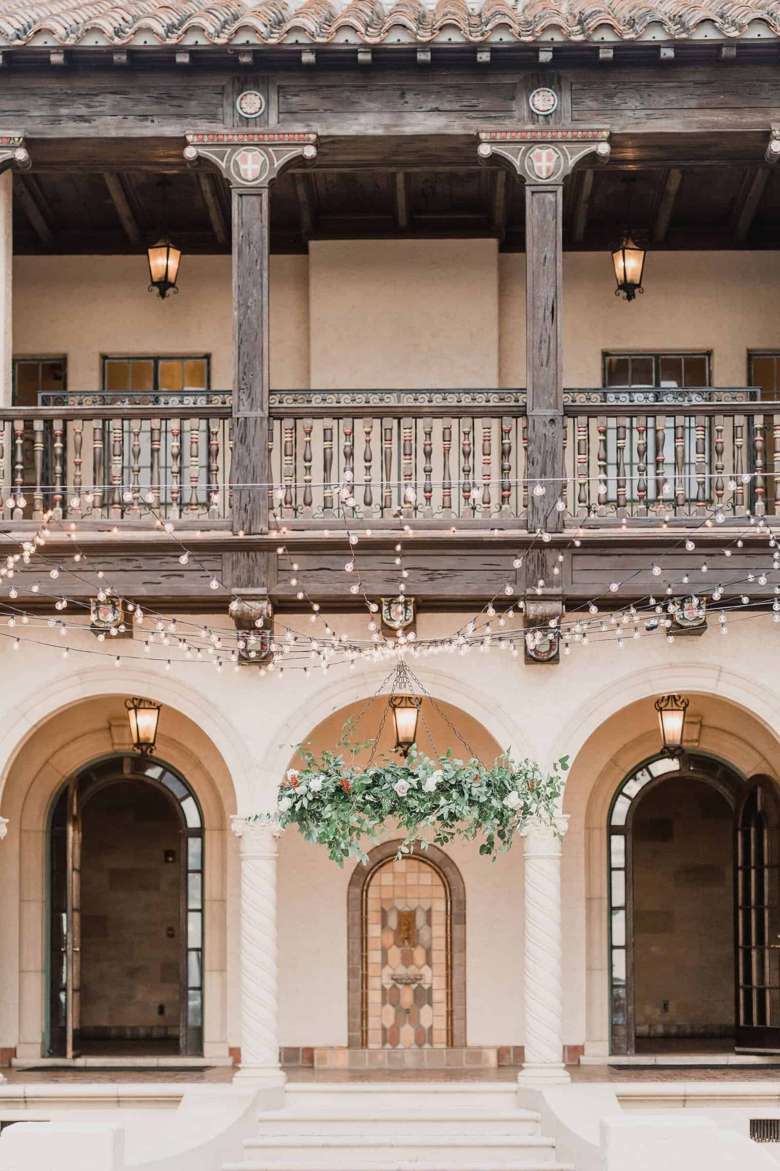 Overhead bistro string lighting and paper lanterns across the courtyard dance floor by Gabro Event Services